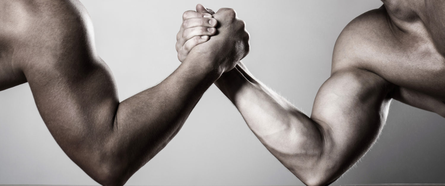 Two men arm wrestling. Rivalry, closeup of male arm wrestling. Two hands. Men measuring forces, arms. Hand wrestling, compete. Hands or arms of man. Muscular hand. Arm wrestling. Black and white.